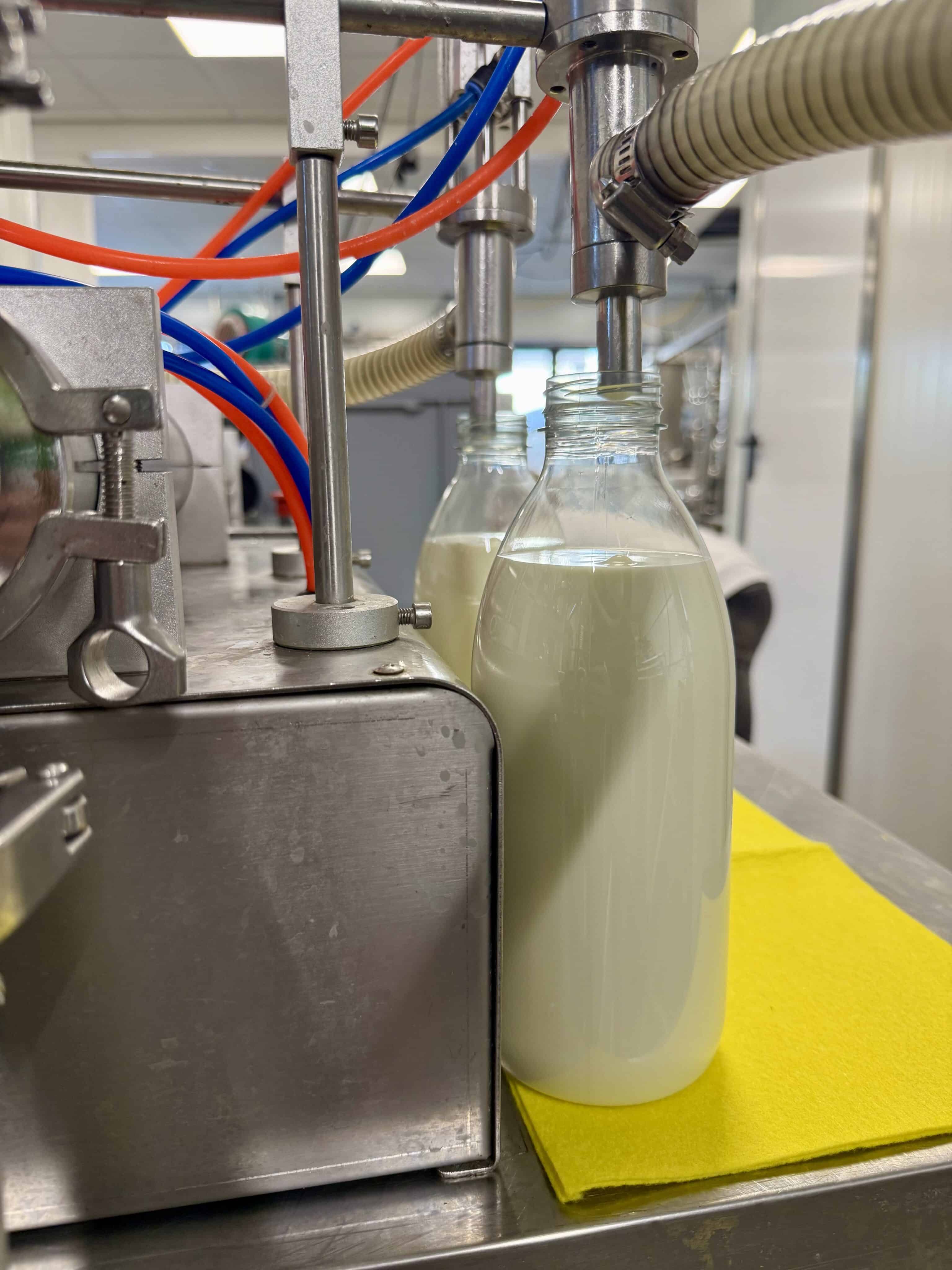 Flessen worden gevuld aan de afvulmachine.
